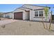 Low-angle view showing the home's garage, the front entrance, and the desert landscaping at 9547 W Parkway Dr, Tolleson, AZ 85353