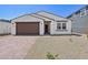 Charming single-story home featuring a brick driveway, a two-car garage, and a low-maintenance desert landscape at 9547 W Parkway Dr, Tolleson, AZ 85353