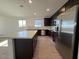 Bright kitchen with stainless steel appliances, quartz countertops, and dark cabinets at 9547 W Parkway Dr, Tolleson, AZ 85353