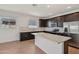 Modern kitchen featuring stainless steel appliances, dark cabinets, and a white countertop island at 9547 W Parkway Dr, Tolleson, AZ 85353