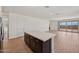 A kitchen island anchors the open-concept space with wood-look tile and modern finishes at 9547 W Parkway Dr, Tolleson, AZ 85353