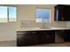 Modern kitchen featuring sleek, dark cabinetry, stainless steel appliances, and a stylish tiled backsplash at 9547 W Parkway Dr, Tolleson, AZ 85353