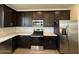 Modern kitchen with stainless steel appliances, dark cabinets, and ample counter space at 9547 W Parkway Dr, Tolleson, AZ 85353