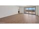 An interior shot showcasing the spacious living room with wood-look tile flooring and large sliding glass doors at 9547 W Parkway Dr, Tolleson, AZ 85353