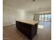 Spacious living room featuring a kitchen island, tile flooring, and a backyard view at 9547 W Parkway Dr, Tolleson, AZ 85353