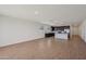 Open-concept living space with a modern kitchen featuring dark cabinets and a breakfast bar at 9547 W Parkway Dr, Tolleson, AZ 85353