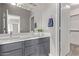 Bathroom with a double sink vanity, a large mirror, and a view into the closet at 10225 W Camelback Rd # 3, Phoenix, AZ 85037