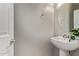 Bathroom featuring a pedestal sink, round mirror, and neutral paint at 10225 W Camelback Rd # 3, Phoenix, AZ 85037