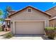 Tan home with a large two car garage, tile roof, desert landscaping, and a bright blue sky at 10225 W Camelback Rd # 3, Phoenix, AZ 85037