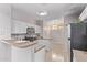 Well-lit kitchen featuring white cabinets, stainless steel appliances, and a breakfast bar at 10225 W Camelback Rd # 3, Phoenix, AZ 85037