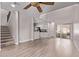 Spacious living room with wood flooring, a fan, an adjacent kitchen area, and stairs to a second floor at 10225 W Camelback Rd # 3, Phoenix, AZ 85037