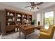This office features a large wooden desk, built-in shelves, and soft lighting at 10225 W Camelback Rd # 3, Phoenix, AZ 85037