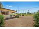 Expansive backyard with low-maintenance gravel, a covered patio, and vibrant flowering bushes at 10429 W Oakmont Dr, Sun City, AZ 85351