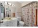 Bathroom with a single sink vanity, standard toilet, and a seashell-themed shower curtain at 10429 W Oakmont Dr, Sun City, AZ 85351