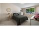 Relaxing bedroom featuring a calming grey bed set and a bright window with lush outside views at 10429 W Oakmont Dr, Sun City, AZ 85351