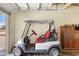 Electric golf cart parked inside garage, offering convenient transportation for the golf course at 10429 W Oakmont Dr, Sun City, AZ 85351