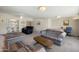Bright living room showcasing neutral carpet, ceiling fan, and comfortable striped sofas at 10429 W Oakmont Dr, Sun City, AZ 85351