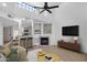 Bright living room featuring vaulted ceilings, fan, fireplace, and an open view of the bar and kitchen at 1126 W Elliot Rd # 2040, Chandler, AZ 85224