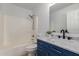 Bright bathroom featuring a combination tub and shower, vanity with granite counters and blue cabinets at 11359 E Elena Ave, Mesa, AZ 85208