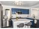 Updated kitchen featuring an island with white counters, stainless steel appliances, and stylish blue cabinets at 11359 E Elena Ave, Mesa, AZ 85208