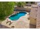 A backyard features a uniquely-shaped pool with rock accents, lounge chairs, and desert landscaping at 11359 E Elena Ave, Mesa, AZ 85208