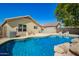 Backyard oasis with a sparkling pool featuring a tranquil rock waterfall and lounge area at 11359 E Elena Ave, Mesa, AZ 85208