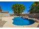Backyard with a sparkling blue pool featuring a tranquil rock waterfall feature and mature landscaping at 11359 E Elena Ave, Mesa, AZ 85208