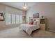 Bright bedroom features a ceiling fan, neutral carpet, and large windows with plantation shutters at 11651 E Appaloosa Pl, Scottsdale, AZ 85259