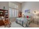 Comfortable bedroom with a large window, plantation shutters, and a wooden rocking chair at 11651 E Appaloosa Pl, Scottsdale, AZ 85259
