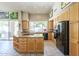 Bright kitchen with granite counters, wooden cabinets, black appliances and large window looking out to the yard at 11651 E Appaloosa Pl, Scottsdale, AZ 85259