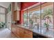 Kitchen sink featuring granite countertops with view of the backyard pool and palm trees at 11651 E Appaloosa Pl, Scottsdale, AZ 85259