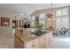 Open floor plan kitchen with stainless steel appliances, a cooktop island, and a view of the dining and living areas at 11651 E Appaloosa Pl, Scottsdale, AZ 85259