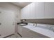 Convenient laundry room with sink, washer, dryer, and ample cabinet space at 11651 E Appaloosa Pl, Scottsdale, AZ 85259
