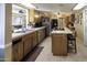 Bright kitchen with tile flooring, a breakfast bar, and wooden cabinetry at 1209 W Tulane Dr, Tempe, AZ 85283