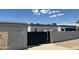 View of the backyard with a private black gate, fence, shed, and desert landscaping at 12805 W Colter St, Litchfield Park, AZ 85340