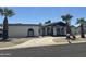 A charming single-story home with a private drive, desert landscaping, and mature palm trees at 12805 W Colter St, Litchfield Park, AZ 85340