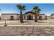 Single-story home with black trim, palm trees, neutral rock landscape, and cracked asphalt drive at 12805 W Colter St, Litchfield Park, AZ 85340