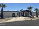 A charming single-story home with a private drive, desert landscaping, and mature palm trees at 12805 W Colter St, Litchfield Park, AZ 85340