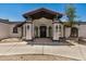 Inviting home exterior with a covered entrance, desert landscaping, and modern lighting fixtures at 12805 W Colter St, Litchfield Park, AZ 85340