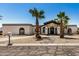 Charming single-story home featuring desert landscaping, palm trees, and a private driveway under a bright blue sky at 12805 W Colter St, Litchfield Park, AZ 85340