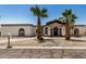Charming single-story home featuring desert landscaping, palm trees, and a private driveway under a bright blue sky at 12805 W Colter St, Litchfield Park, AZ 85340