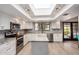 Modern kitchen with white cabinets, stainless steel appliances, a skylight, and granite countertops at 12805 W Colter St, Litchfield Park, AZ 85340