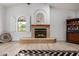 Cozy living room showcasing a tiled fireplace, arched window, and decorative wine rack, creating a relaxing ambiance at 12805 W Colter St, Litchfield Park, AZ 85340