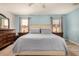 Bright main bedroom with light blue walls, carpeted floors, a ceiling fan and two bedside tables at 12805 W Colter St, Litchfield Park, AZ 85340