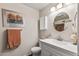 Well-lit bathroom featuring a classic vanity, round mirror, and stylish fixtures at 13608 W Aleppo Dr, Sun City West, AZ 85375