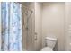 Cozy bathroom featuring a walk-in shower with leafy shower curtain and traditional toilet at 13608 W Aleppo Dr, Sun City West, AZ 85375