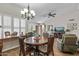 Well-lit dining area featuring wood-look floors, a chandelier, and a large window with plantation shutters at 13608 W Aleppo Dr, Sun City West, AZ 85375