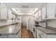 Bright kitchen with white appliances and cabinets, granite countertops, and wood-look tile flooring at 13608 W Aleppo Dr, Sun City West, AZ 85375