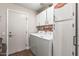 A spacious laundry room with overhead cabinets and a door to the exterior at 13608 W Aleppo Dr, Sun City West, AZ 85375