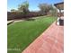 This backyard has a large grassy area and pavers around the house at 15023 W Redfield Rd, Surprise, AZ 85379